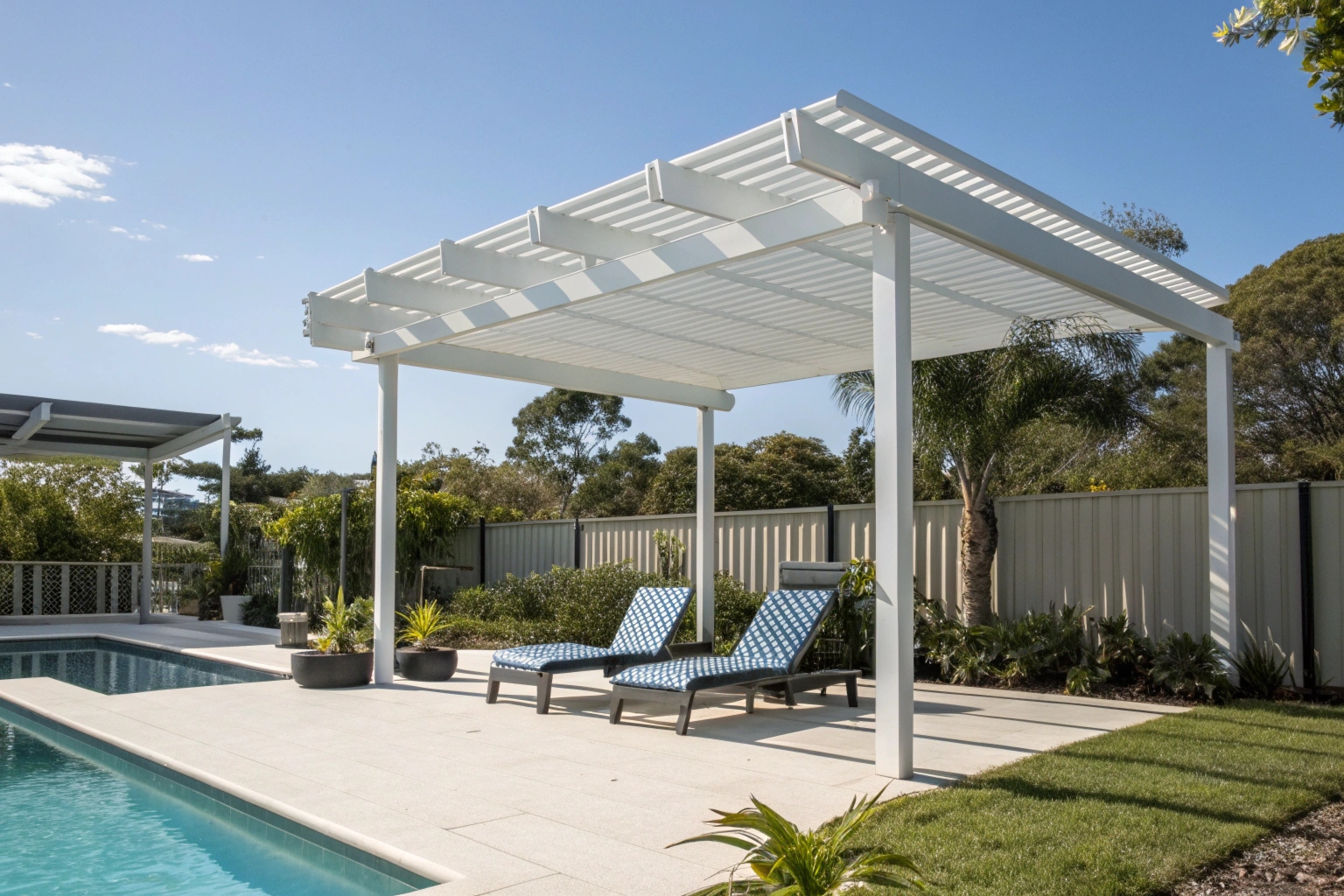 White aluminium pool pergola creating shaded poolside entertaining area